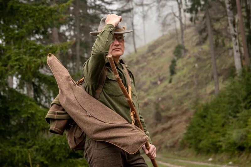 Jäger in Lodenbekleidung vor Bergwald